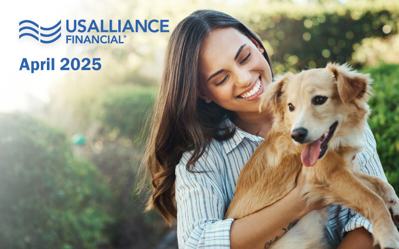 A woman smiling and holding a dog, with USALLIANCE Financial logo and "April 2025" text in the background.