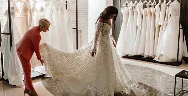 A woman in a wedding dress getting fitted in a store.